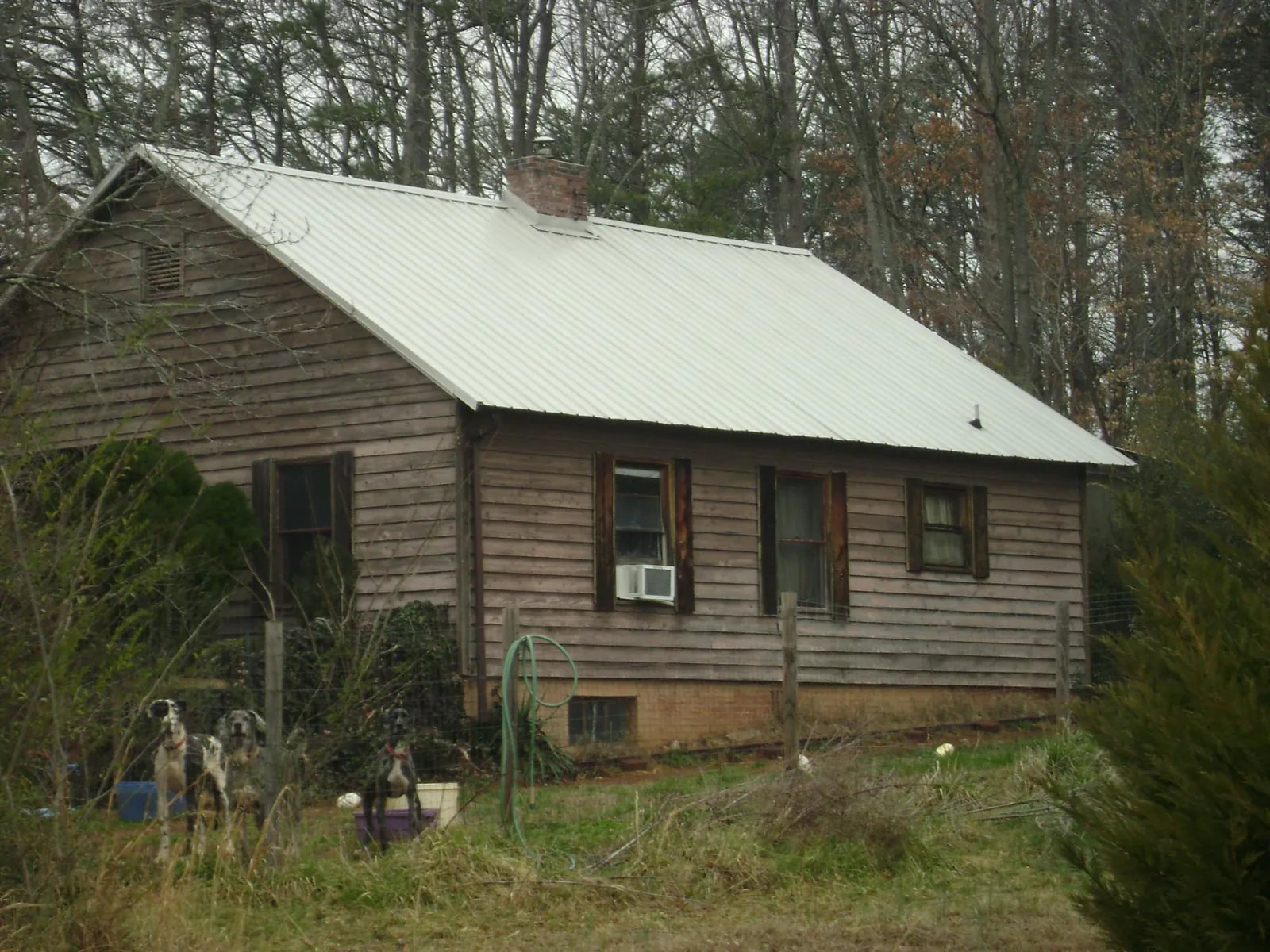 White metal roof on an old wood sided farmhouse, from a Metal Roof Installation job in Polk